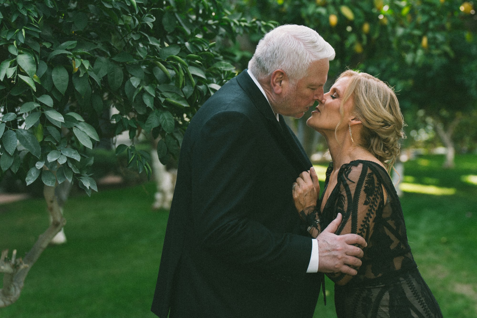 Couple's kiss in a citrus garden, Coachella Valley wedding photography